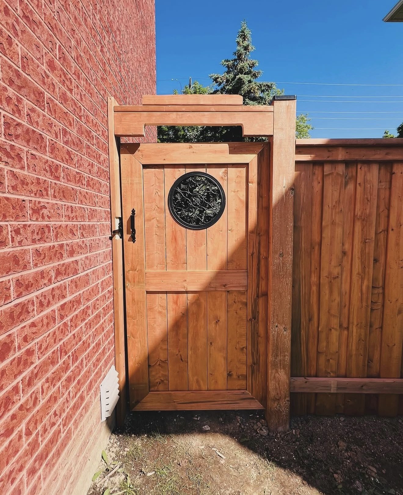 Custom full privacy side gate with decorative round wrought-iron insert