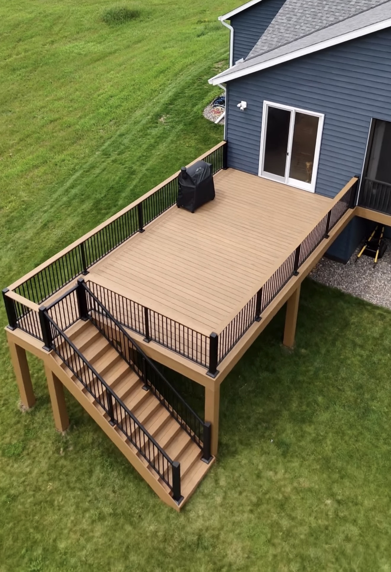 Elevated composite deck with black aluminum railings and full staircase