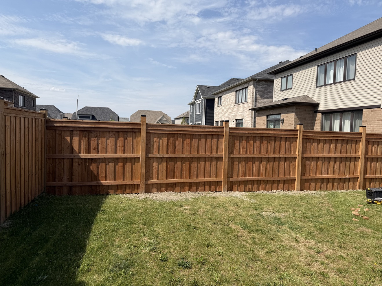 Finished pressure-treated wood privacy fence