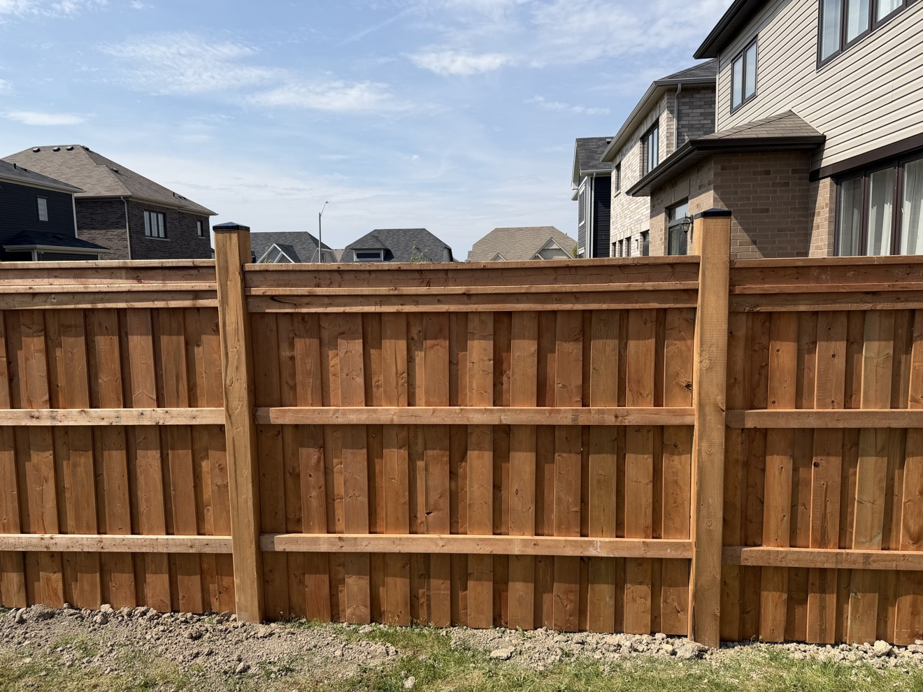 Finished pressure-treated wood fence